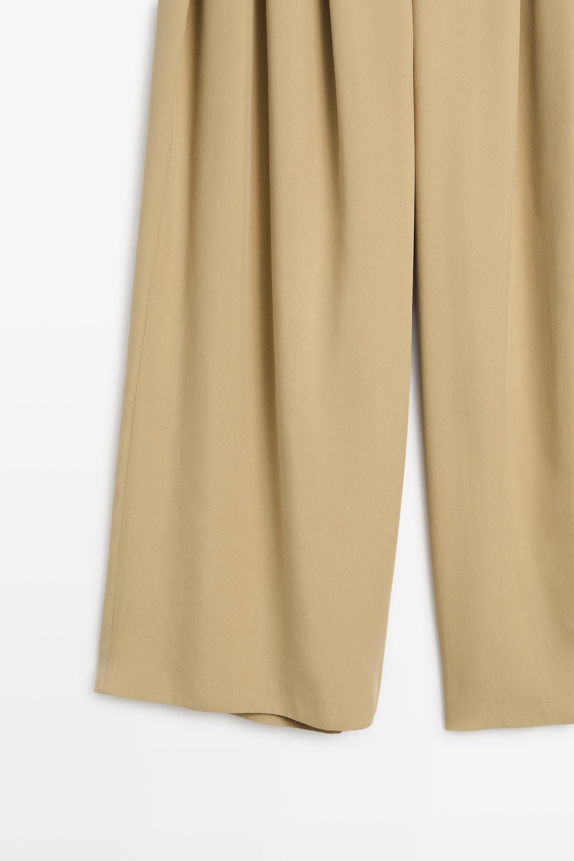 Flowing pleated pants with button detail